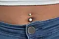 A navel piercing with white closures