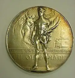 Medal from the 1920 Olympics references the nudity of athletes in the Ancient Olympics