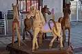 A simple wooden carousel powered by pulling on a wound rope