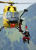 A winch is used to lower someone (in a rescue mission, in the mountains)