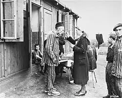 The liberated Neuengamme survivor standing on the right has a triangle patch with a top-bar