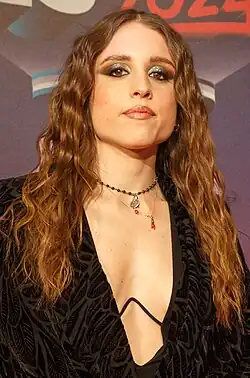 Image of Mango with long red hair, wearing a black dress