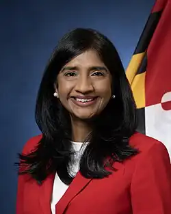 Official portrait of Miller in front of the Maryland flag, wearing a red blazer jacket and white shirt.