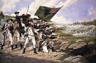 Colonial era soldiers stand and kneel while firing muskets at and advancing enemy. Behind them is a mounted soldier with a bayonet and behind them is a large flag.