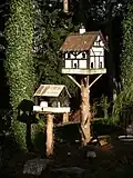 A birdbox designed to look like a human house.