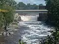 A flowing river with a small waterfall at the end