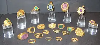 22 gold and jewelled rings in a display case