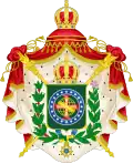 Coat of arms consisting of a shield with a green field with a golden armillary sphere superimposed on the red and white Cross of the Order of Christ, surrounded by a blue band with 20 silver stars; the bearers are two arms of a wreath, with a coffee branch on the left and a flowering tobacco branch on the right; and above the shield is an arched golden and jeweled crown