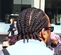 A man with his hair in cornrows.