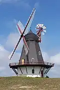 Windmill where the wheel can readjust itself, to capture the wind. An additional gear is needed for rotating the wheel (which can be automated).