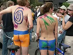 Nudist cyclists at an event, in Fremont, California. They use body-painting for their buttocks.