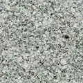 The polished face of a granite slab showing an even pattern of white, greenish and black crystals.