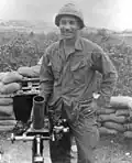A head and torso portrait of a man wearing a helmet and military uniform.