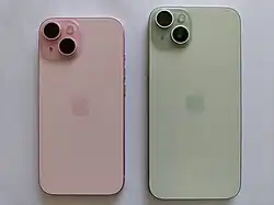 A left back of the iPhone 15 in pink and right back of the iPhone 15 Plus in green