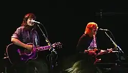 Indigo Girls strumming guitars onstage
