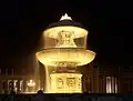 The fountains of Maderna and Bernini are lit up at night.