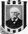 Framed portrait of a white man with a drooping mustache wearing a dark suit coat and bow tie.