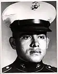 A head and shoulders portrait of a young, cleanshaven man, wearing a formal military uniform and a hat.