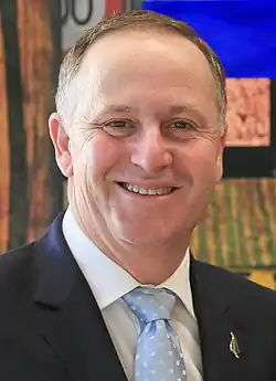 Head and shoulders of John Key in a dark suit and pale blue spotted tie