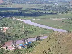 Photograph showing the confluence of the Kagera and Ruvubu rivers with the Rwanda–Tanzania border post in the foreground, taken from a nearby hilltop