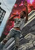 Cudi holding a microphone while singing