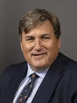 A white man with brown hair and a blue suit