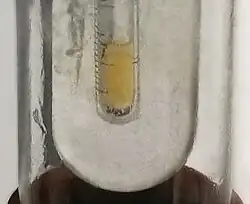 Small sample of pale yellow liquid fluorine condensed in liquid nitrogen