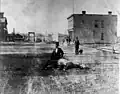 8th Street Sheboygan in the 1890s, featuring a man on a dead horse
