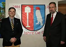 Matthias Laurenz Gräff and Karl von Habsburg in front of the family flag of the anniversary (2022)
