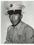alt=A head and shoulders portrait of a young, cleanshaven man with dark hair, wearing a formal military uniform and a hat.