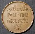 A coin from 1927 - 1948, showing “Palestine” in Arabic, English, and Hebrew. In Hebrew, it also says “Eretz Yisrael” (Land of Israel). The year 1927 is written in two styles of numbers, with a dotted border around the edge.