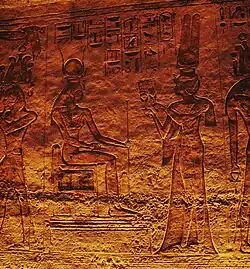 Nefertari offering sistrums to seated goddess Hathor