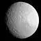 A spherical heavily cratered body is illuminated from the bottom. The terminator runs from the left to right in the vicinity of the top limb. There is a wide curved graben running from the center of the body to the bottom. It is Ithaca Chasma.