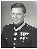 A black and white image showing the head and torso if Pittman wearing his Marine Corps dress uniform with medals. His Medal of Honor is visible around his neck.