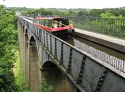 A canal boat crossing the aqueduct. The shape of the iron plates gives the impression of traditional stone voussoirs (2008)