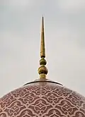 The dome, made of pink and white granite tiles, is a unique feature.