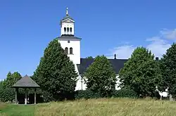 The stone is under a roof and is near the church where it was discovered.
