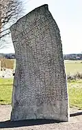 The back of the stone. Elder futhark runes are written at the bottom.