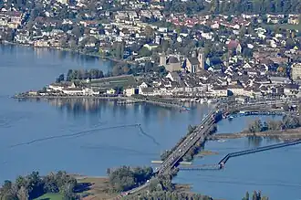 Rapperswil as seen from Etzel mountain: Capuchin monastery to the left, Rapperswil castle and St. John's church in the background, Lake Zürich harbour and Altstadt in the foreground respectively Seedamm, wooden bridge and upper Lake Zurich (Zürichsee) to the right (October 2010)
