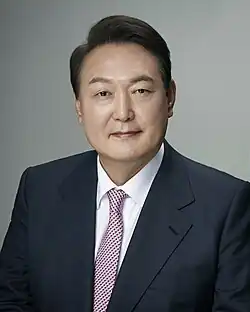 Yoon, 61, facing the camera