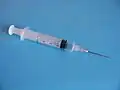 A typical plastic medical syringe, fitted with a detachable stainless steel needle