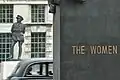 A London cab zooms between two monuments on Whitehall, between Horse Guards and 10 Downing Street
