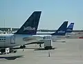 3 JetBlue aircraft at JFK. All JetBlue planes have a different tail design.