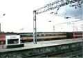 A picture of a Virgin Trains' MK 3 carriage at Crewe station in the year 2000. It is in its former Inter City livery. Most are now either renovated or scrapped. They were too old to use.