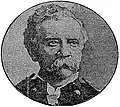 Head of a white man with wavy hair and a drooping mustache wearing a military jacket with shoulderboards.